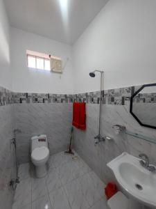 a white bathroom with a toilet and a sink at RED ROSE HOTEL & RESORT Mansehra in Mānsehra