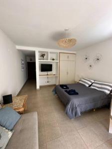 a bedroom with a large bed and a couch at Departamento en planta baja con cochera in Salta