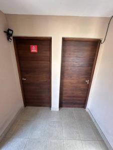 two wooden doors in a hallway with a red sign at Departamento en planta baja con cochera in Salta