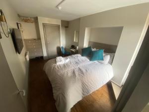 a bedroom with a large bed with blue pillows at Quiet cosy 1 bedroom apartment Carrington F1 in Nottingham