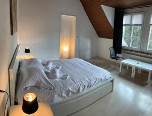 a bedroom with a large white bed and a desk at Superbe Duplex Vue Château et Lac in Neuchâtel