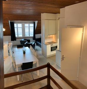 a kitchen and living room with a table and a dining room at Superbe Duplex Vue Château et Lac in Neuchâtel