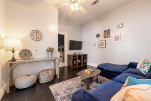 a living room with blue couches and a tv at Galveston Victorian - Walk to the Strand and Beach in Galveston