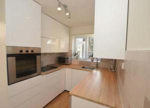 a kitchen with white cabinets and a wooden counter top at Cosy & Peaceful 3B Home in Sandridge, St Albans in Saint Albans