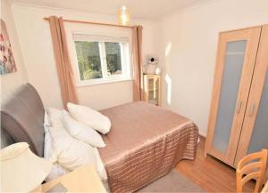 um pequeno quarto com uma cama e uma janela em Cosy & Peaceful 3B Home in Sandridge, St Albans em Saint Albans