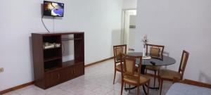ein Esszimmer mit einem Tisch und Stühlen sowie einem TV in der Unterkunft Departamento zona terminal/parque in Dolores
