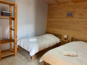 two twin beds in a room with wooden walls at Hometainer Río Cochrane 2 in Cochrane