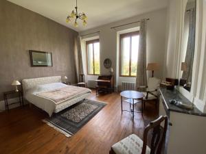 1 dormitorio con cama, mesa y algunas ventanas en Domaine de Bernou, en La Croix-Blanche
