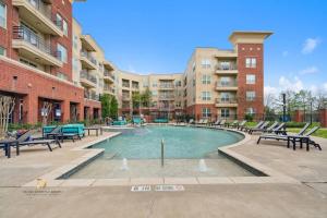 a pool in a courtyard with benches and buildings at Houston Med Center Modern Queen Suite with Spa Amenities, Pool and Free Parking in Houston