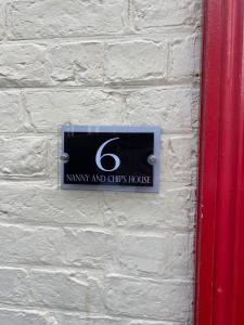 a sign on a brick wall with the number five at Nanny and Chips House in Whitby