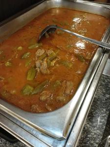 a pan of stew with a spoon in it at Petra Cabin Hostel in Wadi Musa