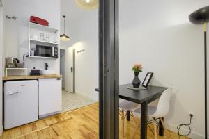 a kitchen with a table and a small kitchen with white cabinets at MEZZANINE ORANGE in Madrid
