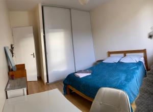 a bedroom with a bed with a blue comforter at Chambre Angers gare-centre ville 2 in Angers