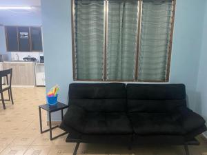 czarna kanapa w salonie z oknem w obiekcie Boca Vieja #1 w mieście Quepos
