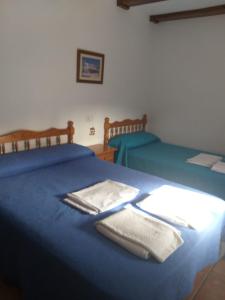 a blue bed with two towels on top of it at CASAS RURALES LA TOBICA in Yeste