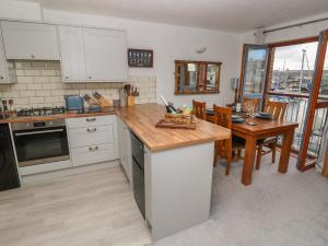 a kitchen with white cabinets and a wooden counter top at The Sail Loft in Milford Haven