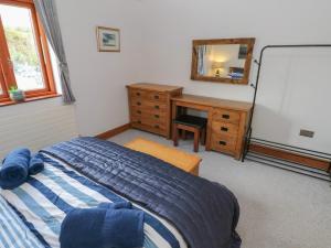 1 dormitorio con cama, tocador y espejo en The Sail Loft en Milford Haven