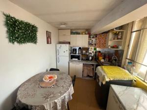 a small kitchen with a table and a refrigerator at Departamento Céntrico cómodo y acogedor in Puno