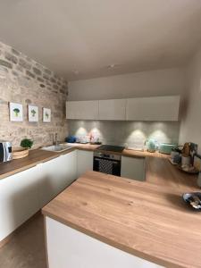 uma cozinha com um balcão de madeira num quarto em Maison de ville atypique avec terrasse et poêle em Fontenay-sous-Bois