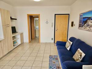 un soggiorno con divano blu e un corridoio di SE052 - Marotta, delizioso bilocale con giardino a Marotta