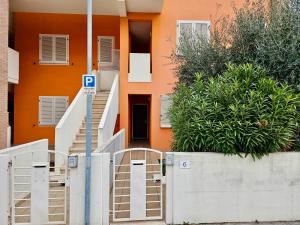 un edificio naranja con una señal de estacionamiento delante de él en SE052 - Marotta, delizioso bilocale con giardino, en Marotta
