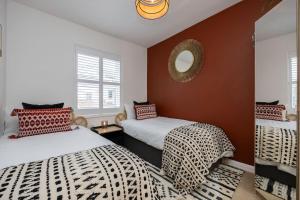 een slaapkamer met 2 bedden en een spiegel aan de muur bij Stunning modern space in Hove & free parking in Brighton & Hove