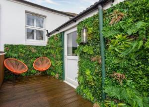 een groene muur met twee stoelen en een deur bij Stunning modern space in Hove & free parking in Brighton & Hove