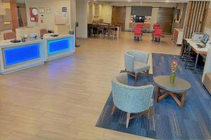 una sala d'attesa con sedie e tavoli in ospedale di Holiday Inn Express Hotel & Suites Lincoln South, an IHG Hotel a Lincoln