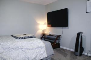 een slaapkamer met een bed en een flatscreen-tv bij MD Cozy Corner in Johnson City