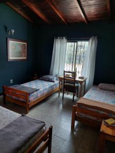 um quarto com 2 camas, uma secretária e uma janela em Tatami Hostel em Bucaramanga