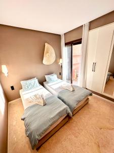1 dormitorio con 2 camas y ventana en Stunning Apartment - Panoramic pool view en Marrakech