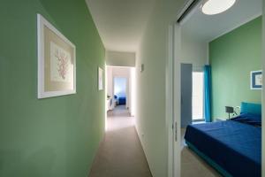 ein Schlafzimmer mit grünen Wänden, einem Bett und einem Flur in der Unterkunft Appartamenti vista mare Otranto in Otranto