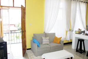 a living room with a couch and a window at Afrodig Apartment in Arusha