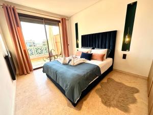 1 dormitorio con 1 cama y ventana grande en Stunning Apartment - Panoramic pool view, en Marrakech