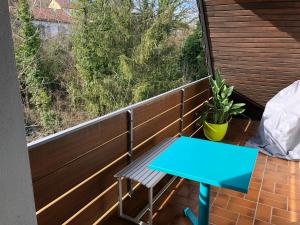 uma mesa azul numa varanda com vista em Blaues Zimmer mit grossem Balkon & Bad nur 16 km nach Würzburg! em Mainstockheim