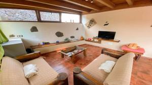 a living room with two couches and a tv at Casita Mis Chinijos con Jacuzzi o Minipiscina in La Asomada