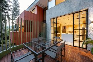 a house with a glass table and chairs on a deck at Casa Penta Top Notch Villa in Medellín