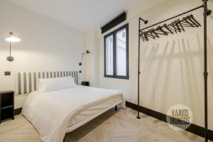 een slaapkamer met een wit bed en een raam bij Wonderful Apt para 7 en Preciados-Plaza del Carmen in Madrid