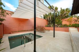 a swimming pool with an umbrella next to a building at Casa Penta Top Notch Villa in Medellín
