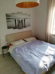 a bed in a bedroom with a blue blanket at Delizioso trilocale Lodi città in Lodi