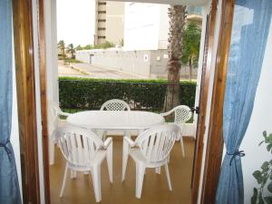 - Balcón con mesa blanca y sillas en Aldeas Taray Admer 10, en La Manga del Mar Menor