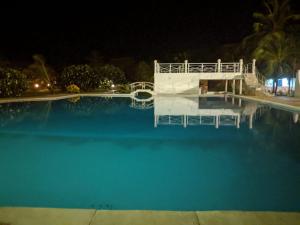 - une grande piscine d'eau bleue la nuit dans l'établissement Karibuni Villa - Malindi beach view property, à Malindi