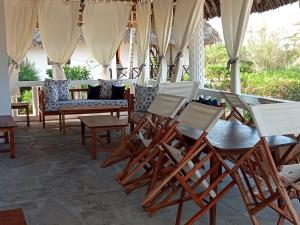 - un ensemble de chaises et de tables sur une terrasse dans l'établissement Karibuni Villa - Malindi beach view property, à Malindi