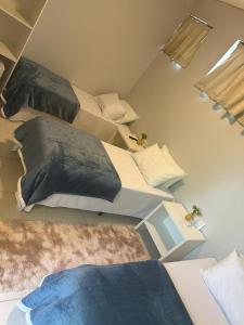 a room with three beds with pillows on them at Recanto Catarina in Cascavel