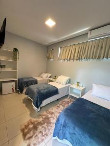 a hotel room with two beds and a couch at Recanto Catarina in Cascavel