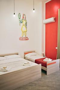 Pokój z dwoma łóżkami i obrazem na ścianie w obiekcie Cortile dei Giusti - Combo Guesthouse w mieście Palermo
