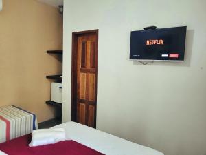 a room with a tv on the wall and a bed at News Hospedagem in Paraty