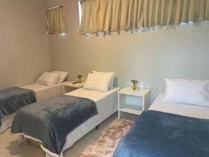 a room with two beds and two night stands at Recanto Catarina in Cascavel