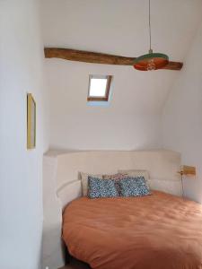 a bedroom with a bed with a brown bedspread at La Garencière - La Petite Maison in Champfleur