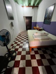 a room with a bed and a checkered floor at Casona del Negro Aguilar in Valladolid